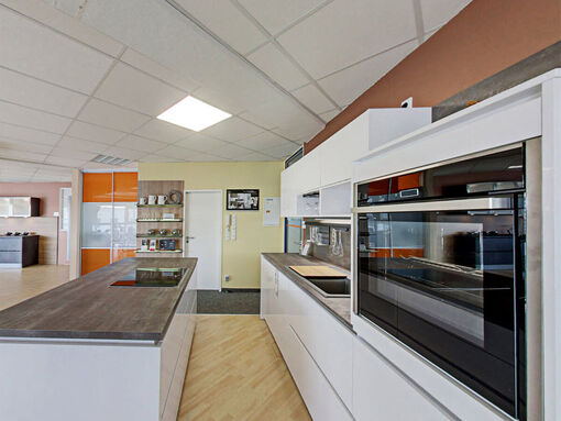 Moderne Küche in Hochglanz weiß mit hochwertigen Elektrogeräten. 