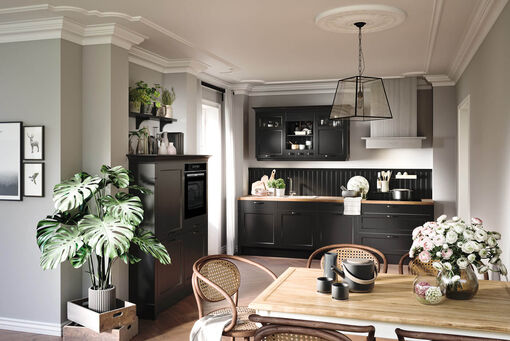 Schwarze Rahmenfronten, kombiniert mit einer hellen Arbeitsplatte, lassen diese Küche elegant und edel wirken.